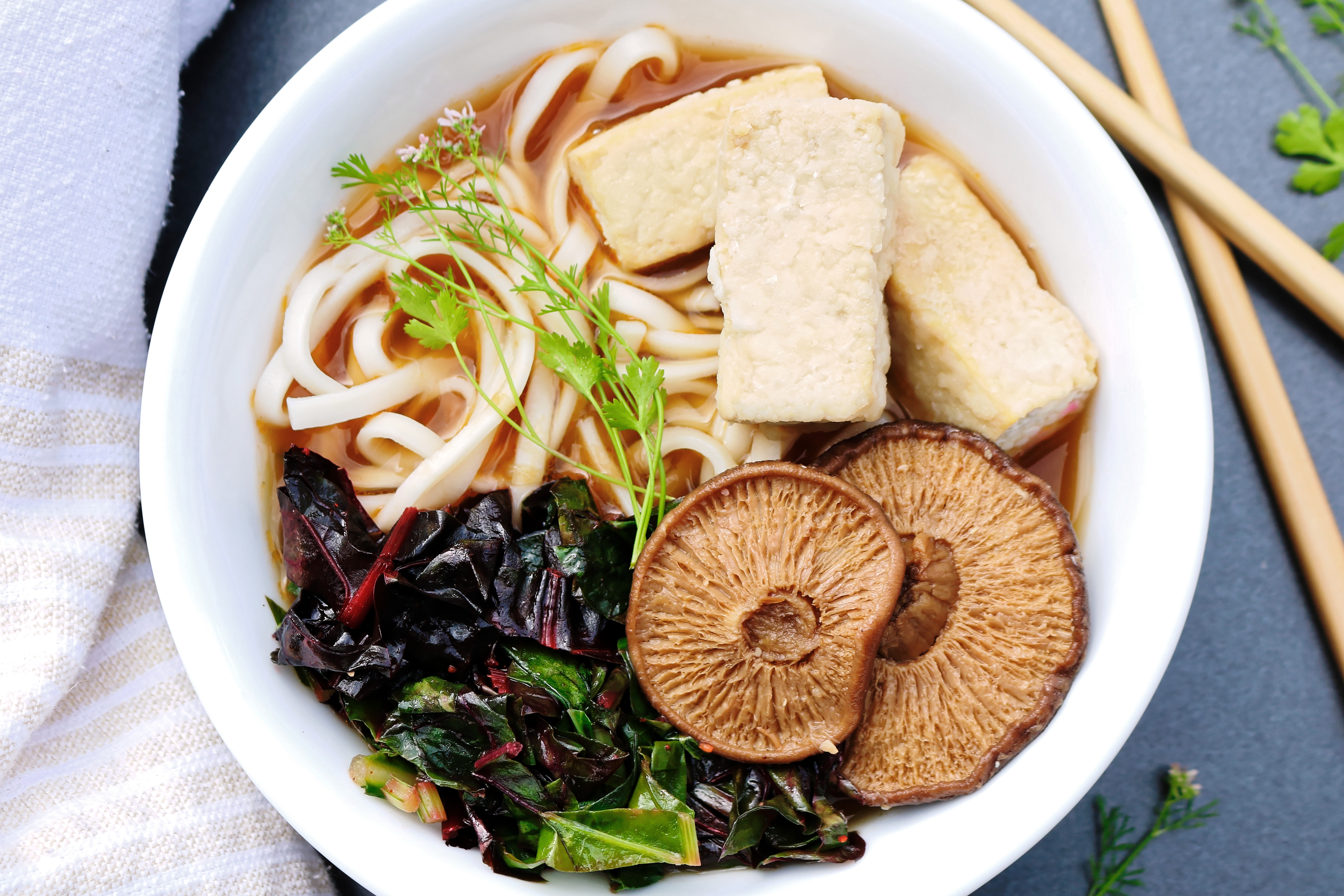 Vegan vegetarian ramen with broth soup noodles mushrooms tofu and cooked greens top view