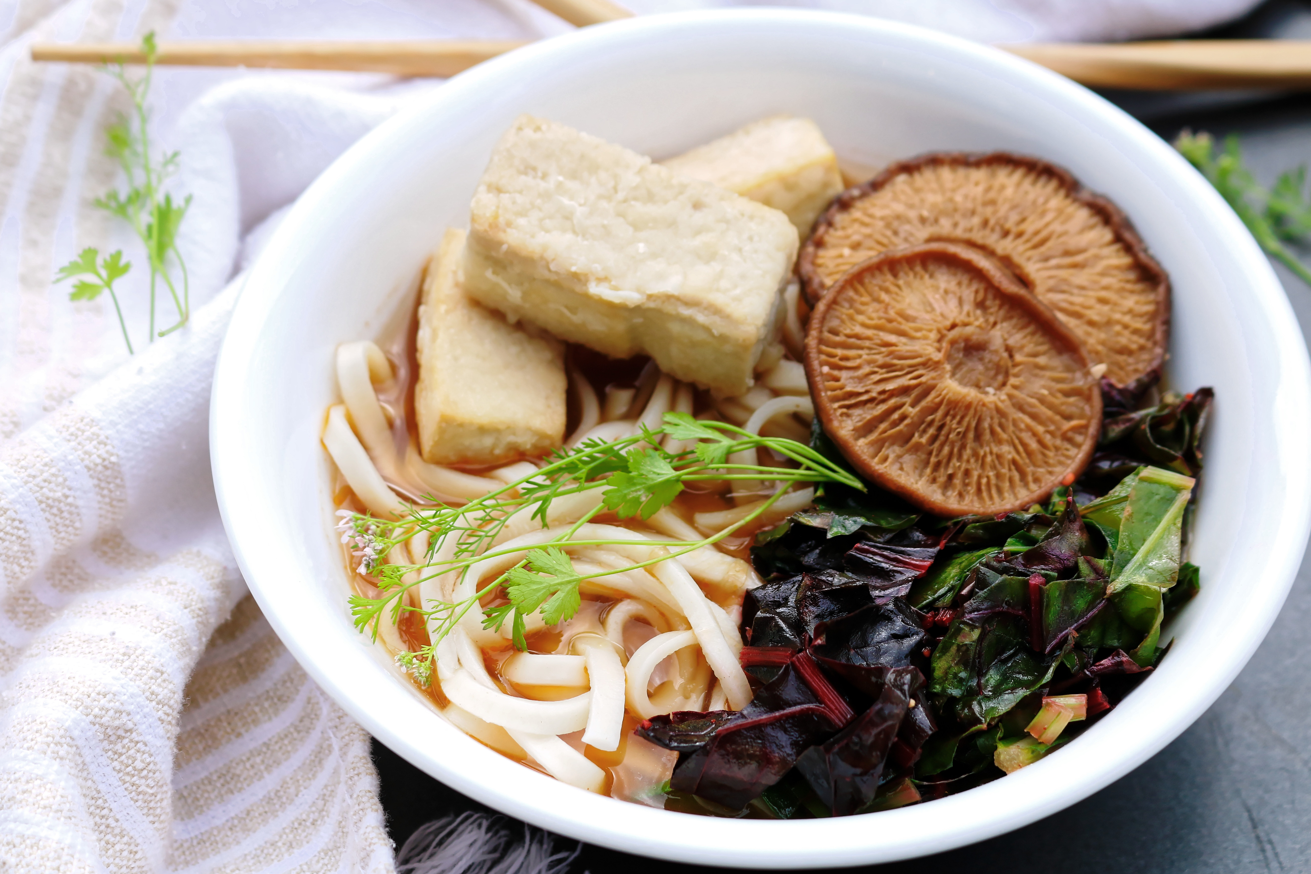 Vegan vegetarian ramen with broth soup noodles mushrooms tofu and cooked greens